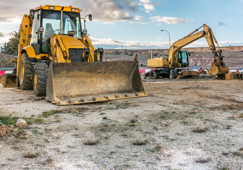 canteiro de obras​ com retroescavadeira e escavadeira hidráulica